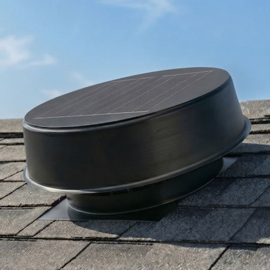 Black roof vent on a shingled roof with a clear blue sky.